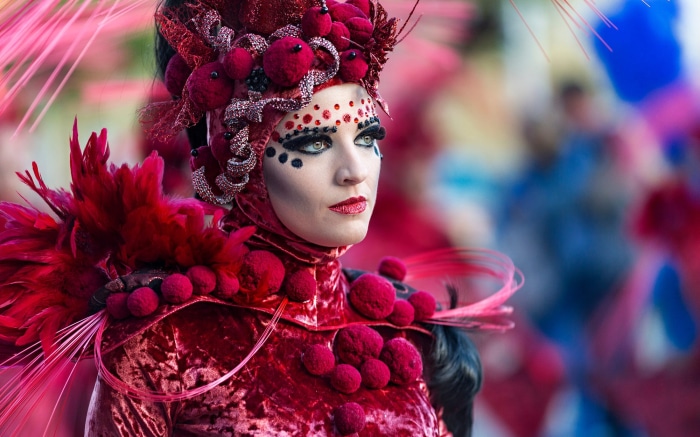Woman in elaborate red carnival costume and makeup