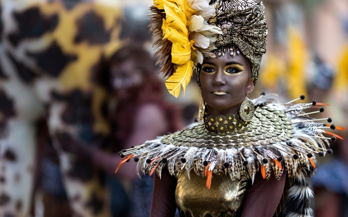 Woman in elaborate carnival costume with feathers and gold