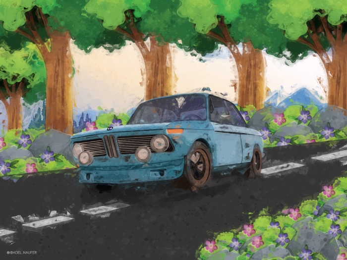 Blue vintage car driving on a road through a forest