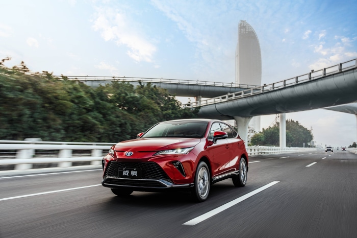 Red Toyota Venza Hybrid driving on a highway