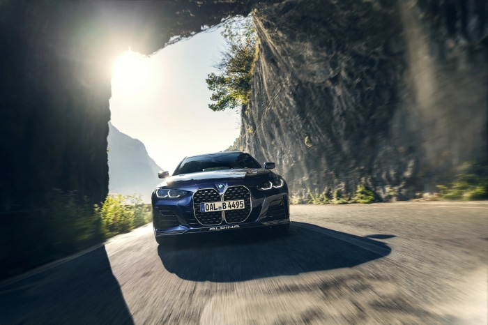 Alpina B4 Gran Coupé driving through a mountain pass