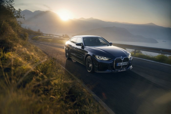 Alpina B4 Gran Coupé driving on a mountain road at sunset
