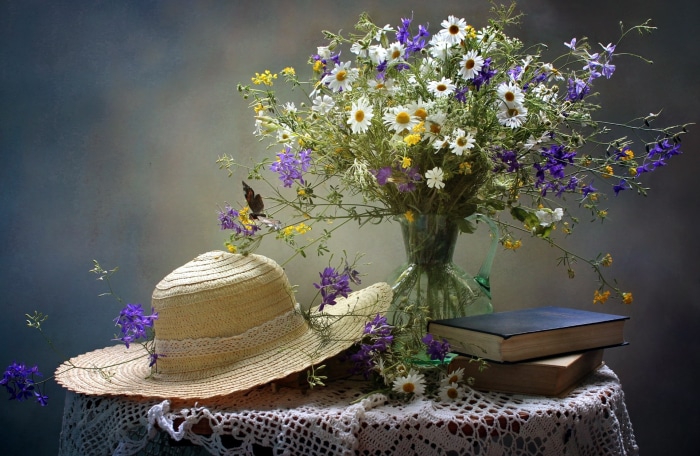 Still life with wildflowers, hat, and books