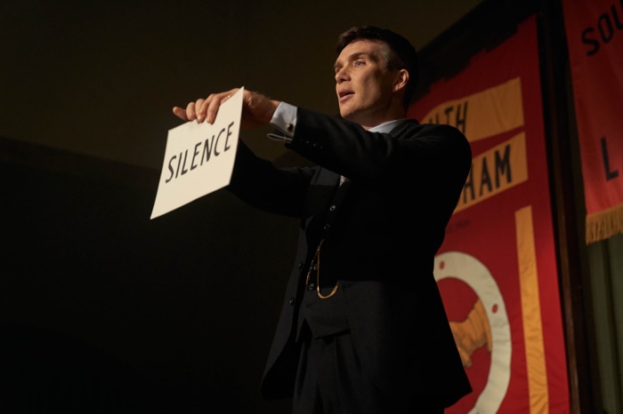 Thomas Shelby from Peaky Blinders holding a sign