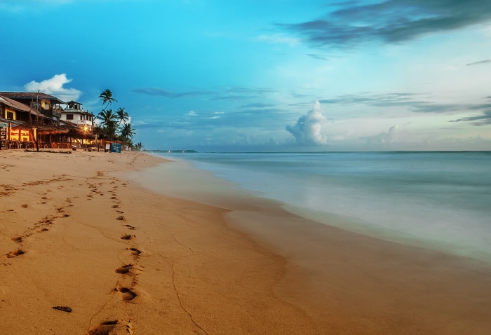 Beach with footprints and ocean at dusk