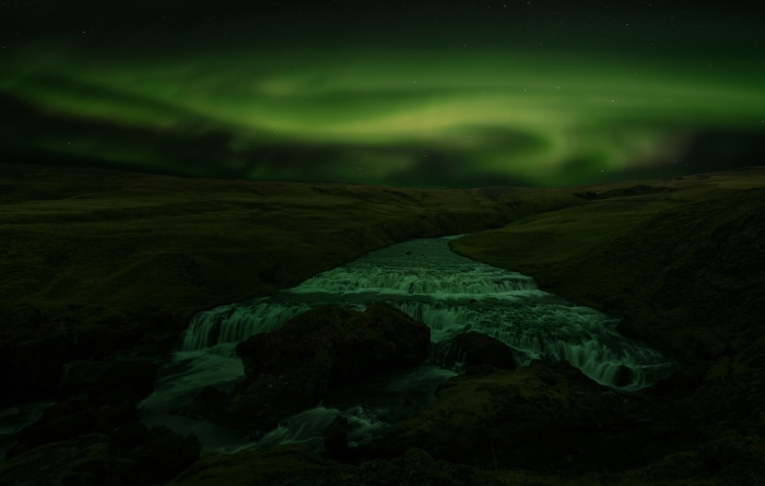 Aurora Borealis over a Waterfall at Night