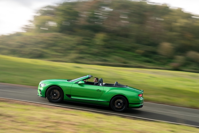 Green Bentley Continental GT V8 Convertible driving on road