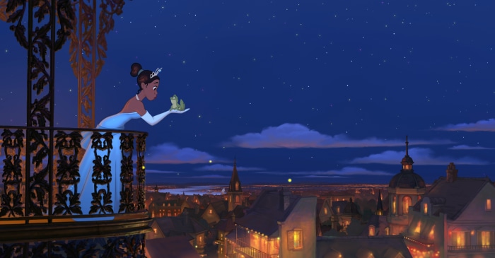 Tiana and a frog on a balcony overlooking a city at night