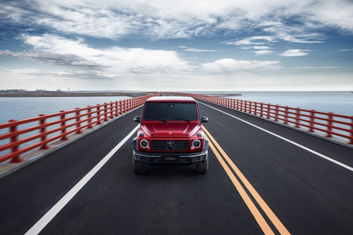 Red Mercedes-Benz G-Class driving on a bridge