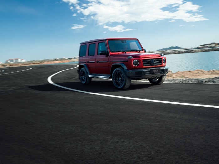Red Mercedes-Benz G-Class driving on a road