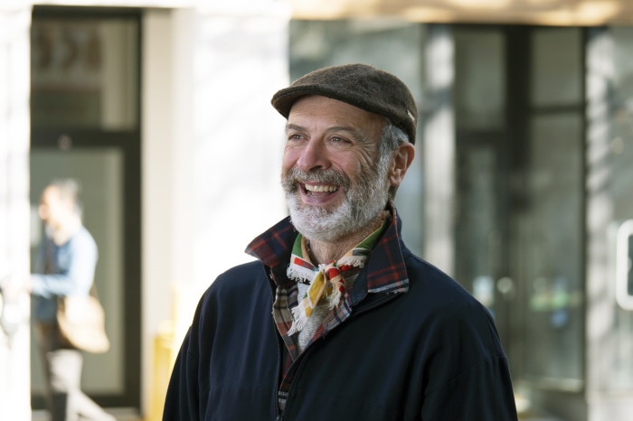 Man wearing a flat cap and scarf