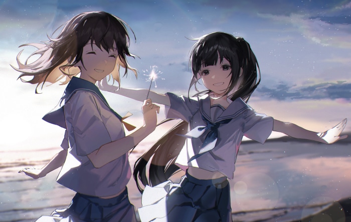 Two friends enjoying a sunset with a sparkler