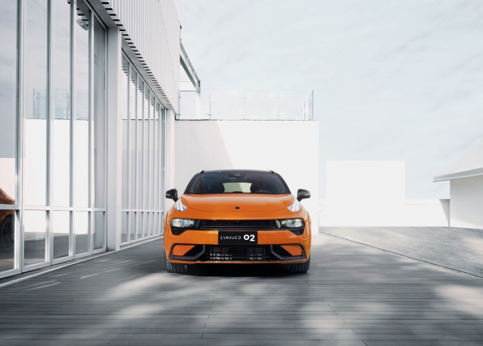 Orange Lynk & Co 02 Hatchback parked outside modern building