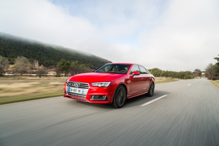 Red Audi A4 Sedan driving on a road