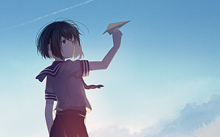 Girl in school uniform throwing a paper airplane