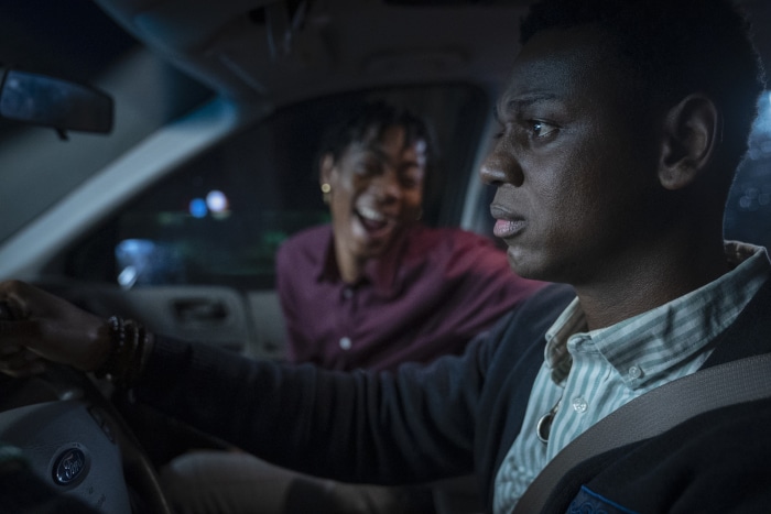 Two young Black men in a car at night
