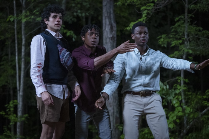 Three young men in a forest at night