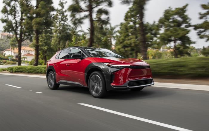 Red Toyota BZ4X driving on a road