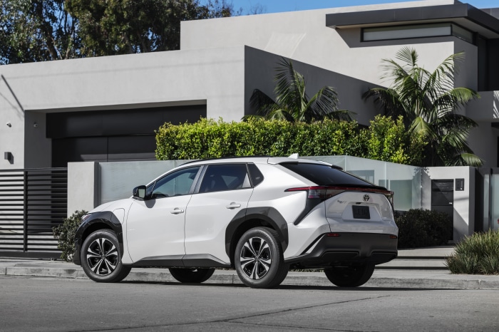 White Toyota BZ4X parked in front of a modern house