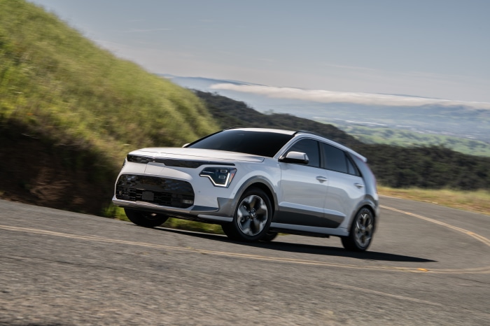 White Kia Niro driving on a winding road