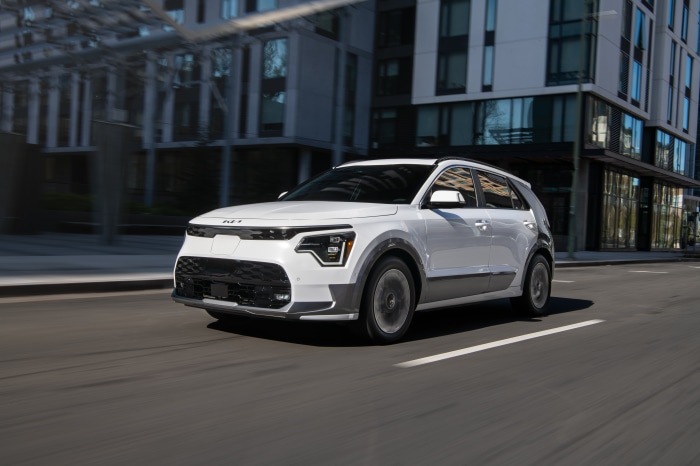 White Kia Niro driving on a city street