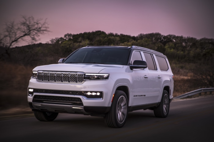 White Jeep Grand Wagoneer driving on a road