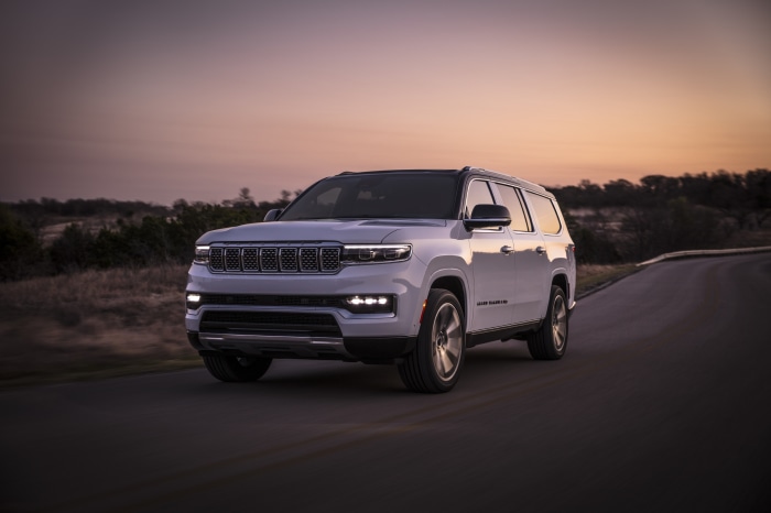 White Jeep Wagoneer HD driving on a road at sunset