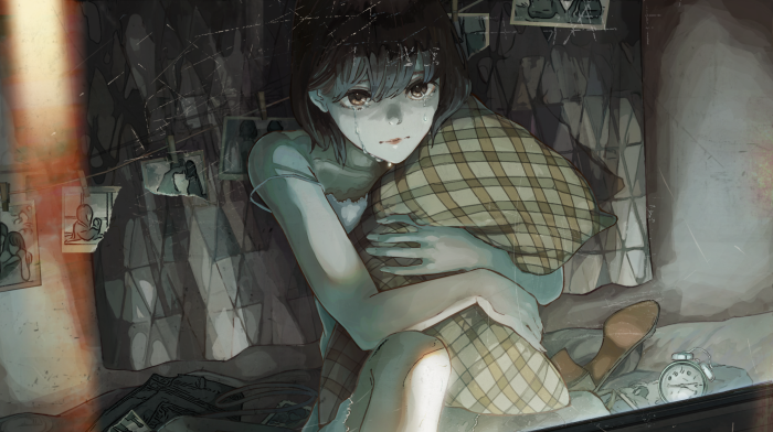 Crying girl holding a pillow in a dark room