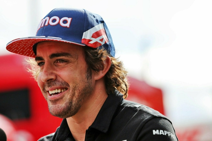 Fernando Alonso wearing a blue and red cap