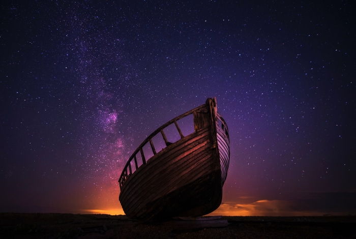 Wrecked boat under starry sky 4K