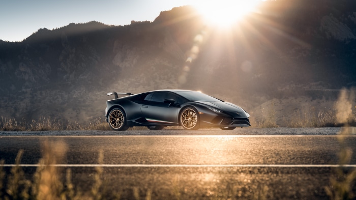 Black Lamborghini Huracan on a road with mountains