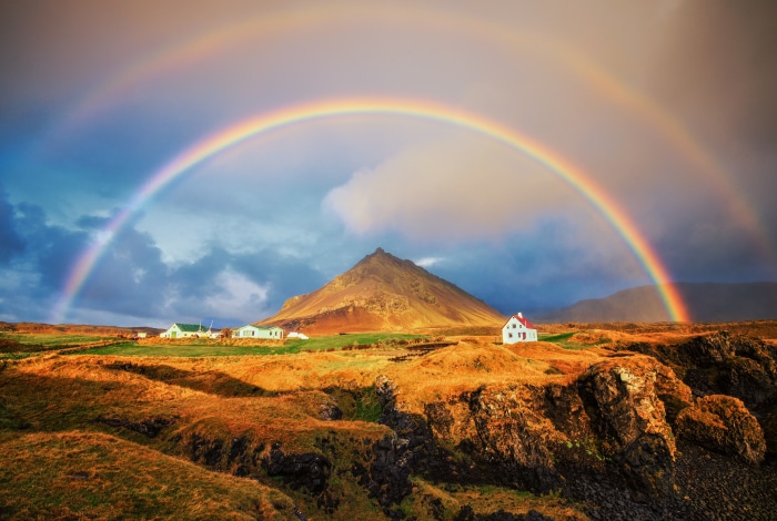 Double rainbow over Icelandic landscape with houses