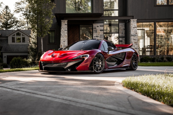 Red McLaren P1 parked in front of a modern house