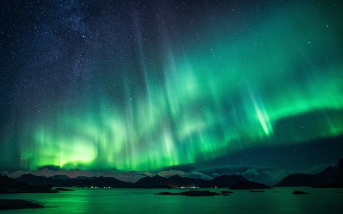 Aurora Borealis over a lake and mountains 4K