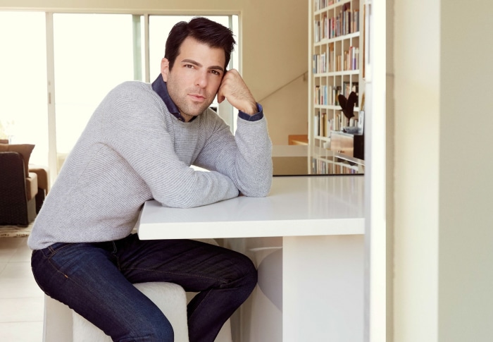 Zachary Quinto sitting at a counter