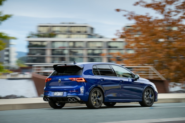 Blue Volkswagen Golf R driving on a road