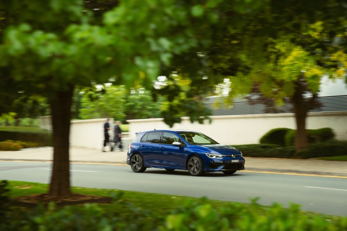 Blue Volkswagen Golf R driving on a road