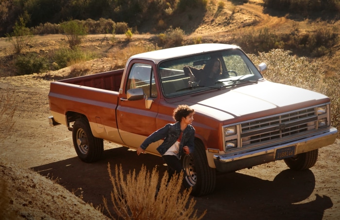 Girl running next to a pickup truck