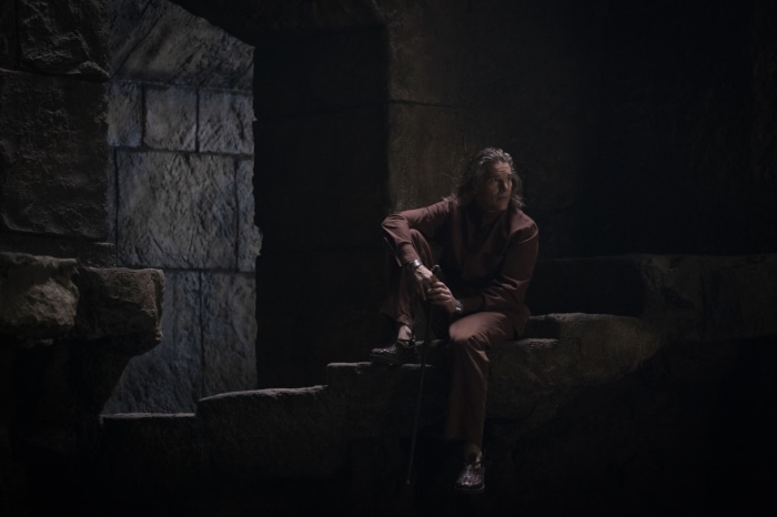 Arthur Harrow from Moon Knight sitting on stone steps