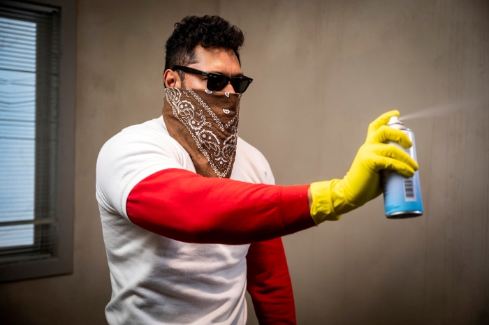 Man in bandana and sunglasses spraying aerosol can