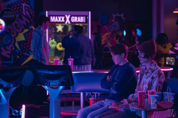 Nick and Charlie from Heartstopper in an arcade