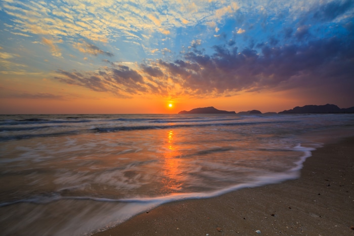 Sunset over the ocean with mountains