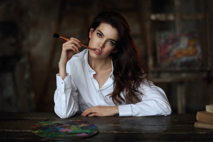 Woman holding paintbrush in studio