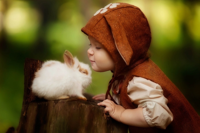Child in bunny costume with a rabbit