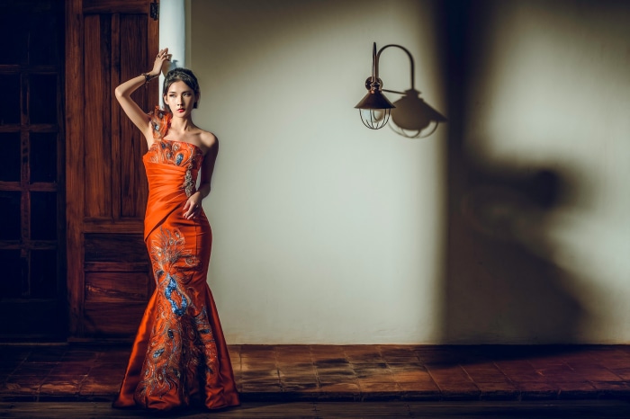 Woman in orange dress with peacock design