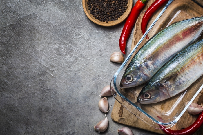 Two raw fish with chili peppers and garlic