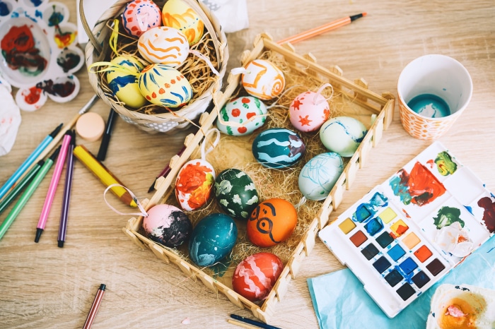 Easter eggs and art supplies on a wooden table