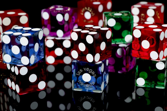 Colorful dice with white dots on black background