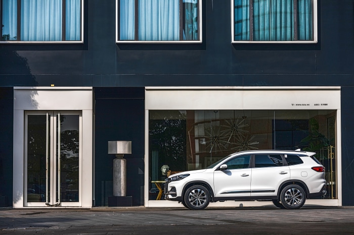 White Chery Tiggo 8 parked in front of a modern building