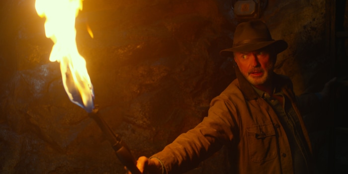 Sam Neill from Jurassic World: Dominion holding a torch